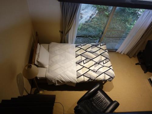 a bedroom with a bed with white sheets and a window at Oimatsuen in Saku