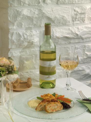 a bottle of wine and a plate of food and a glass at Gästehaus Wilgersdorf GmbH in Wilnsdorf