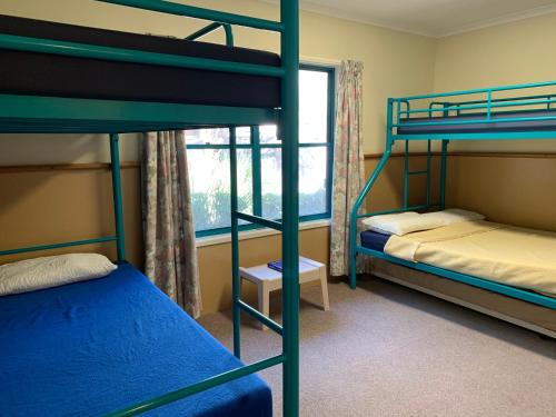 een slaapkamer met 2 stapelbedden en een raam bij Camp Elim in Forster