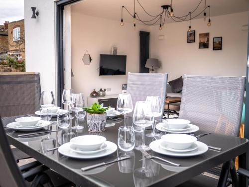 a black table with glasses and plates on it at Broadstairs Apartments with luxurious 4-person communal hot tub - sleeps up to 20 people in Broadstairs