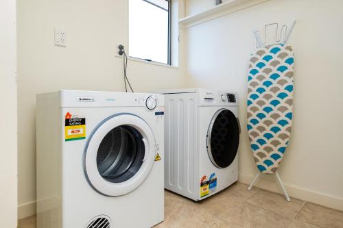 a washer and a washing machine in a room at Parkside Cottage in Napier
