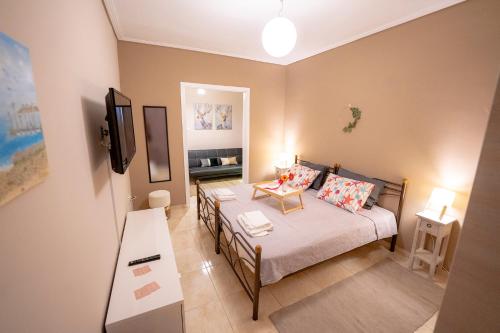 een kleine kamer met een bed en een televisie bij Anthia Seaview Apartment in Kalamata