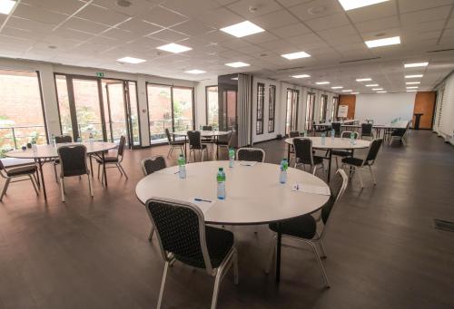 a large room with tables and chairs and windows at ONOMO Hotel Dakar in Dakar
