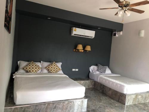 two beds in a room with a black wall at Relax Resort in Nakhon Sawan