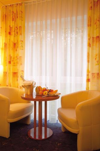 a room with a table and two chairs and a window at Gästehaus Wilgersdorf GmbH in Wilnsdorf