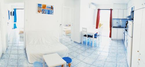 a white kitchen with a white couch and a table at Domus Dulcis Domus in Hersonissos