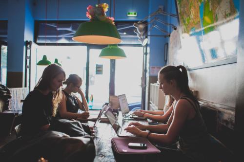 a group of women sitting at a table with laptops at Copenhagen Downtown Hostel in Copenhagen