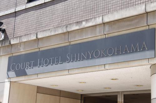 ein Schild an der Seite eines Gebäudes in der Unterkunft Court Hotel Shin-Yokohama in Yokohama