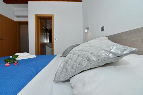a bed with a pillow and a flower on it at Apartments Blaza in Božava