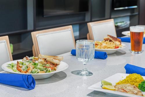 a table with plates of food and glasses of beer at Holiday Inn Melbourne-Viera Conference Ctr by IHG in Melbourne