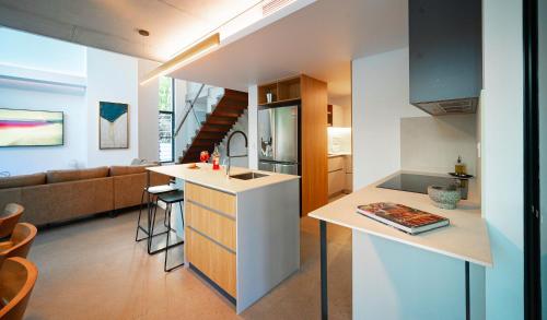 a kitchen and living room with a kitchen island in a house at Aria Port Douglas Villas - Villa 1 in Port Douglas