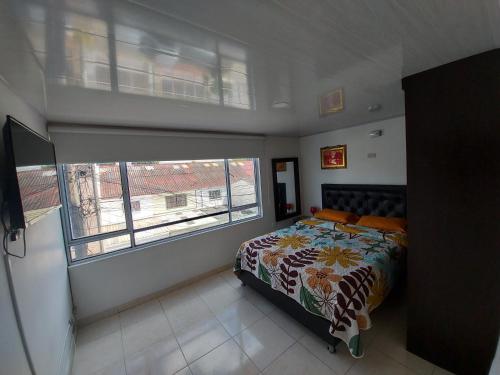 a bedroom with a bed and a large window at Apartamentos YNJ in Bogotá