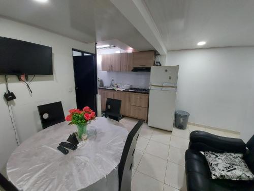 a kitchen with a table with a vase of flowers on it at Apartamentos YNJ in Bogotá