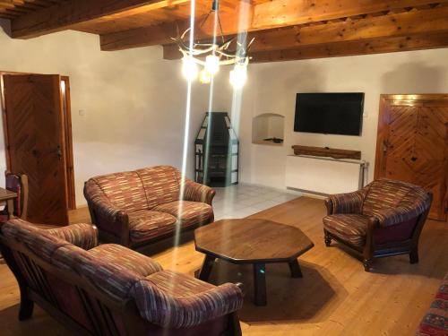 a living room with couches and a table and a tv at Kubovka 63 in Kubova Huť