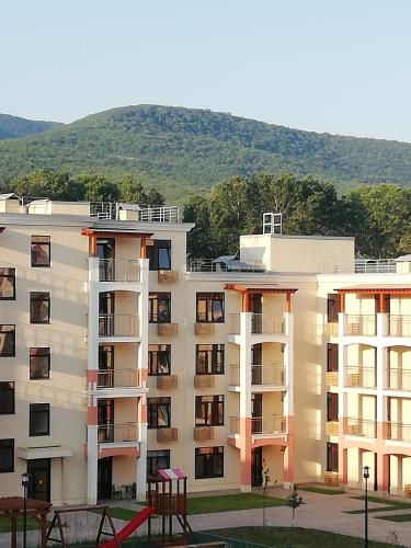 a large apartment building with a mountain in the background at Apartment HOLIDAY HOUSE in Sukko