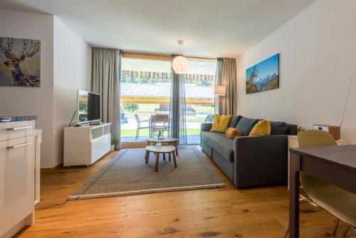 a living room with a couch and a table at Montela Apartment-Hotel & Resort in the holiday region Saas-Fee Saastal in Saas-Grund