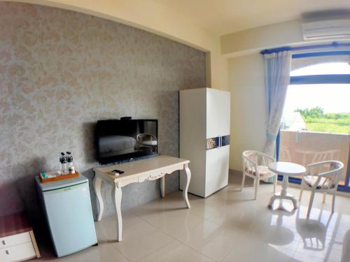 a kitchen with a refrigerator and a table with a microwave at 花蓮驛站-星宸旅宿-寵物友善入住-下單後請留意私訊-備品可加購YouTube 來開箱 in Jian
