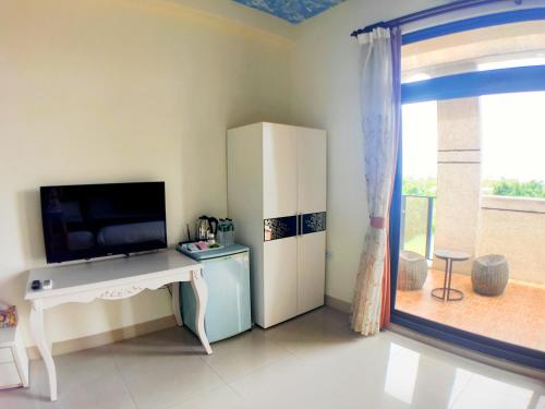 a living room with a television and a refrigerator at 花蓮驛站-星宸旅宿-寵物友善入住-下單後請留意私訊-備品可加購YouTube 來開箱 in Jian