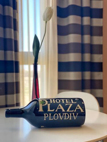 a blue bird vase on a table with a flower at Plaza Hotel Plovdiv - Free Parking in Plovdiv