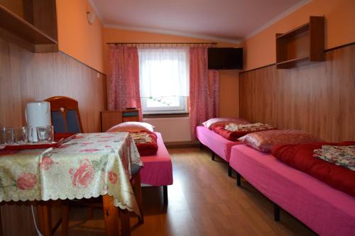 カルウフにあるOśrodek Wypoczynkowy Pod Szczelińcemのベッド4台と窓が備わる客室です。
