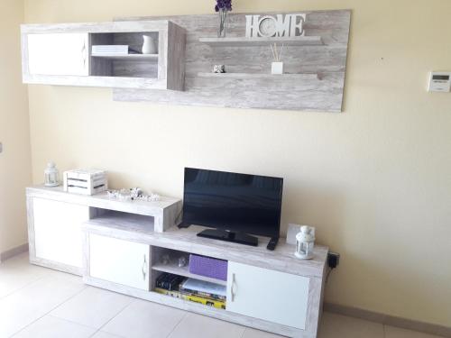 a living room with a tv on a white entertainment center at Costa Dorada Miami in Miami Platja