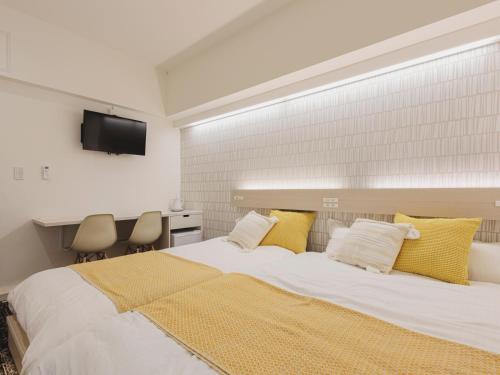 a bedroom with a large bed with yellow pillows at 3rd PLACE by HIDEOUT in Fujisawa