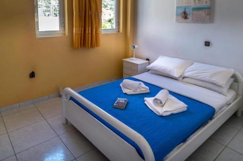 a bedroom with a bed with two towels on it at Alexandra Apartments in Stoupa
