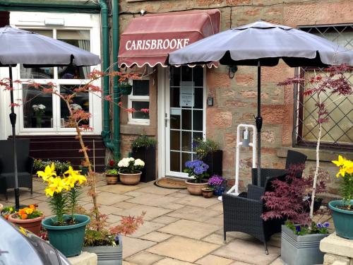 a store with an umbrella and flowers in front of it at Carisbrooke Guest House in Inverness