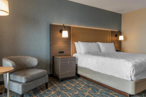 a hotel room with a bed and a chair at Holiday Inn Kingston - Waterfront by IHG in Kingston