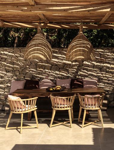 a table and two chairs in front of a stone wall at Mimi and Coco Villas Corfu in Paramonas