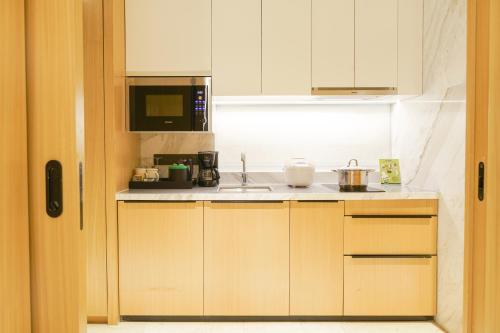 a small kitchen with a sink and a microwave at Holiday Inn Nanjing Qinhuai South Suites by IHG in Jiangning