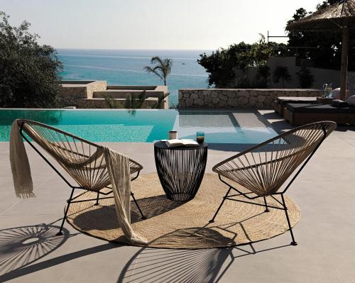 two chairs and a table next to a pool at Mimi and Coco Villas Corfu in Paramonas