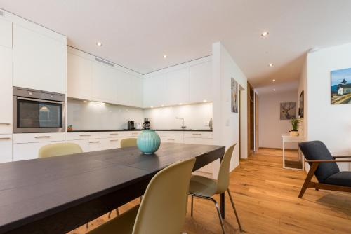 a kitchen and dining room with a table and chairs at Montela Apartment-Hotel & Resort in the holiday region Saas-Fee Saastal in Saas-Grund