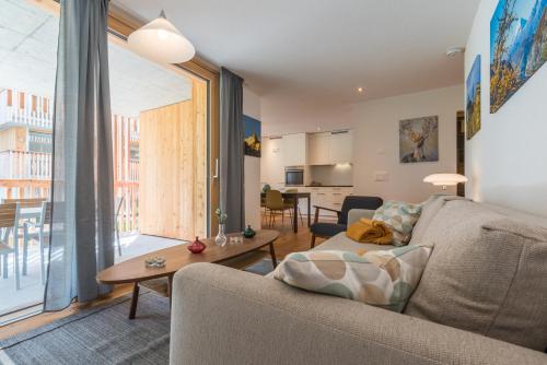 a living room with a couch and a table at Montela Apartment-Hotel & Resort in the holiday region Saas-Fee Saastal in Saas-Grund