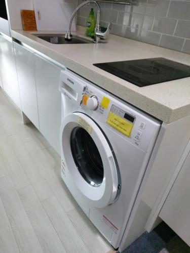a washing machine in a kitchen next to a sink at ARA Palace Hotel in Jeju