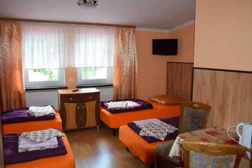 a room with three beds and a window at Ośrodek Wypoczynkowy Pod Szczelińcem in Karłów