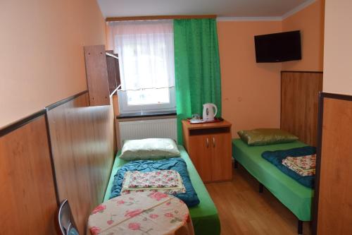 Habitación pequeña con 2 camas y ventana en Ośrodek Wypoczynkowy Pod Szczelińcem en Karłów