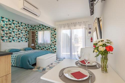 a bedroom with a bed and a table with a vase of flowers at La Petite Californie in Saint-Illiers-la-Ville