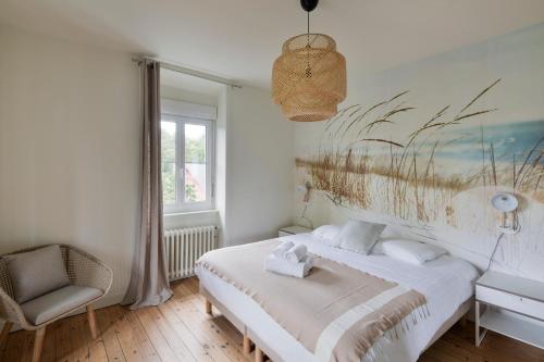 ein Schlafzimmer mit einem Bett und einem Gemälde an der Wand in der Unterkunft Villa Marlotte by Cocoonr - La Belle de Dinard in Dinard