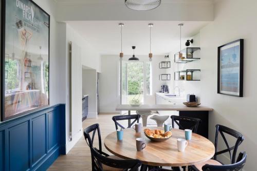 une cuisine et une salle à manger avec une table et des chaises en bois dans l'établissement Villa Marlotte by Cocoonr - La Belle de Dinard, à Dinard