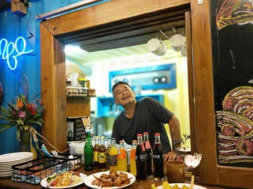 a man standing behind a counter with plates of food at Flower and Green Collection in Shunan