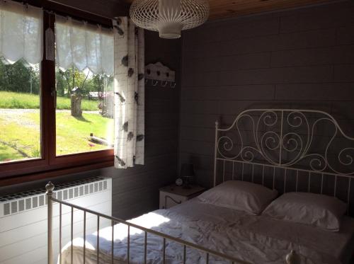 Schlafzimmer mit einem Bett und einem Fenster in der Unterkunft La Hotteuse in Chiny