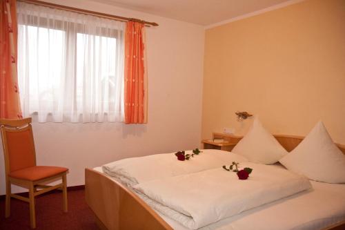 ウダーンスにあるEhstandhofのベッドルーム1室(花が咲く白いベッド1台付)