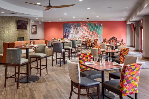 a restaurant with tables and chairs and a mural at Hotel Indigo San Antonio Riverwalk by IHG in San Antonio