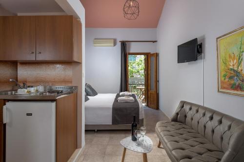 a living room with a couch and a bedroom at Grace Hotel & Studios in Symi