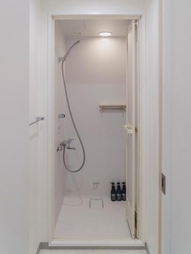 a white bathroom with a shower with a hose at 3rd PLACE by HIDEOUT in Fujisawa