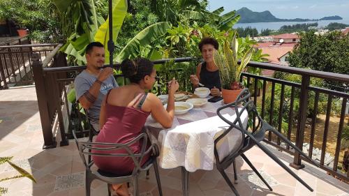 a group of people sitting at a table on a balcony at CHEZ LORNA 3 nights or plus in De Quincey Village
