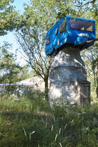 a blue bus sitting on top of a rock at La Belle Folie in Ploemel