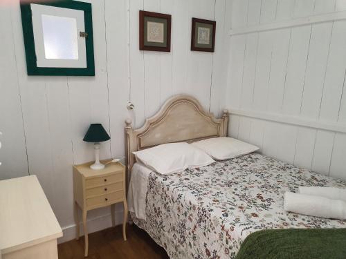 1 dormitorio con 1 cama y 1 mesa con lámpara en Palheiro Costa Nova, en Costa Nova