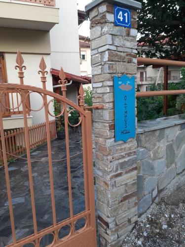 a gate with a stone pillar with a sign on it at OLYMPUS HILL in Litochoro